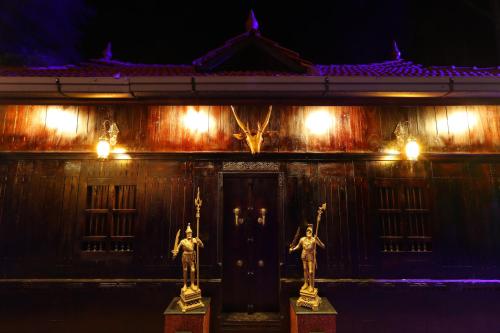 a building with two statues in front of it at night at Castillo De Woods , The Private Luxury Villa , 8 BHK, Vattavada in Kottakamboor