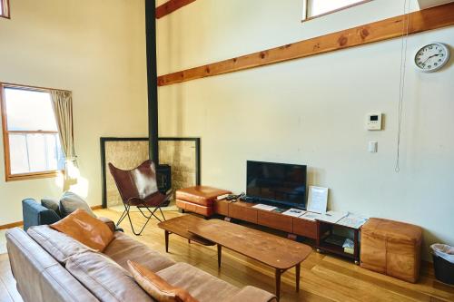 a living room with a couch and a tv at TOOD一宮 -B棟 in Ichinomiya