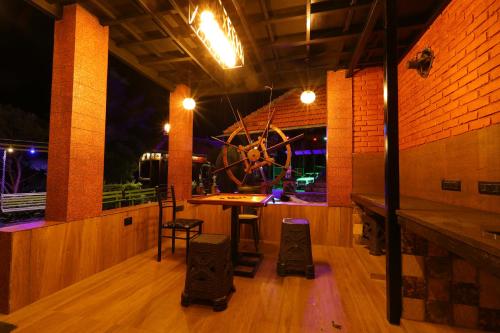 a room with a table and chairs and a large wheel at Castillo De Woods , The Private Luxury Villa , 8 BHK, Vattavada in Kottakamboor