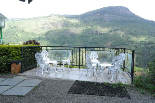 a patio with a table and chairs and a mountain at Castillo De Woods , The Private Luxury Villa , 8 BHK, Vattavada in Kottakamboor