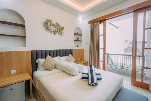 ein Schlafzimmer mit großem Bett und Balkon in der Unterkunft The Lavana Sahadewa Villa Kuta Sunset in Legian