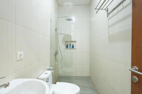 ein Badezimmer mit Dusche, Toilette und Waschbecken in der Unterkunft The Lavana Sahadewa Villa Kuta Sunset in Legian