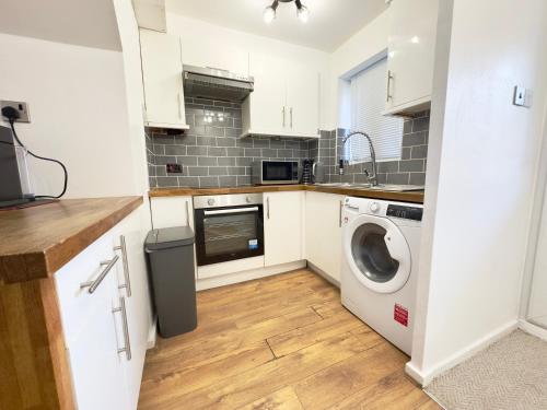a kitchen with a washing machine and a washer at The Cozy Hideaway - 2 Bedroom apartment with garden in Orpington with free Parking in Foots Cray