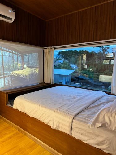 a bedroom with a large bed with a large window at B tree Retreat homestay in Thôn Dương Phẩm