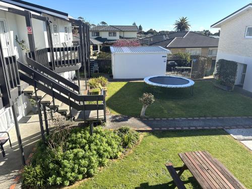 a backyard with a bench and a fire pit at Parkside Motel and Apartments in New Plymouth