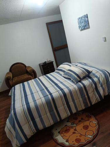 a bed in a bedroom with a blanket on it at OCTAWAHOMe in Cayambe