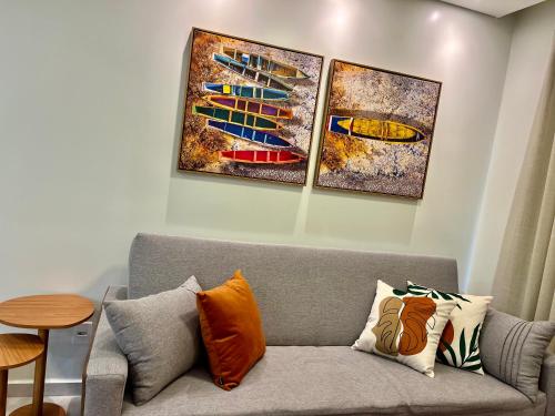伊列乌斯Refúgio Pé na Areia - Ilhéus Vog Marine Praia的客厅的沙发,墙上有三幅画