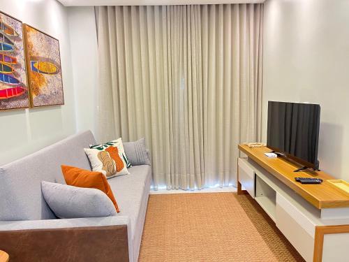 伊列乌斯Refúgio Pé na Areia - Ilhéus Vog Marine Praia的客厅里有一张沙发和一台电视