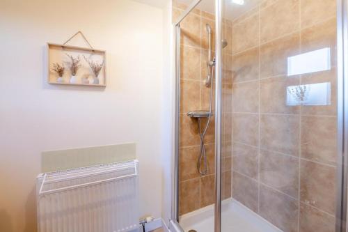 a bathroom with a shower with a glass door at Kendo Retreat- Herrington Park in Elvington