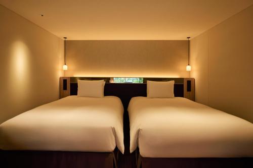 two beds sitting next to each other in a room at ふふ東京銀座 in Tokyo