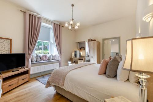 a bedroom with a bed and a flat screen tv at Woodhaven in Grange Over Sands