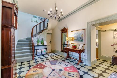a hallway with a staircase and a table and a rug at Woodhaven in Grange Over Sands