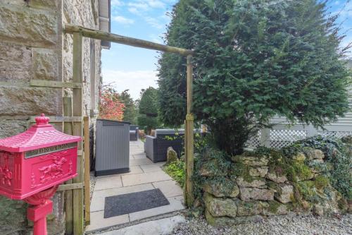 a red fire hydrant next to a stone wall at Woodhaven in Grange Over Sands