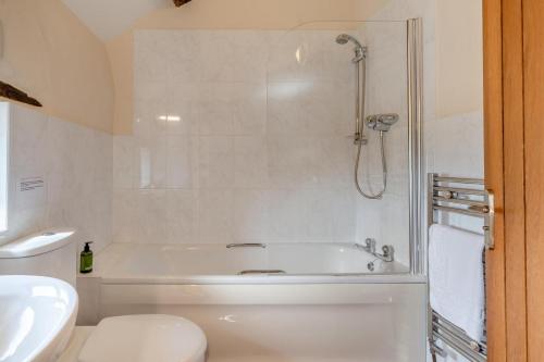 ein Badezimmer mit Badewanne, Toilette und Waschbecken in der Unterkunft Damson Cottage - Waberthwaite in Waberthwaite