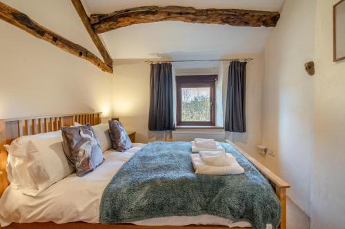 ein großes Bett in einem Zimmer mit Fenster in der Unterkunft Damson Cottage - Waberthwaite in Waberthwaite