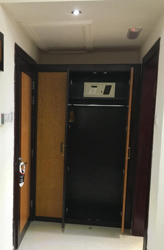 a black refrigerator in a room with a door at Muscat International Hotel Plaza in Salalah