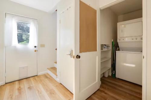 a hallway with a white door and wooden floors at Cambria Mountain View Retreat in Cambria
