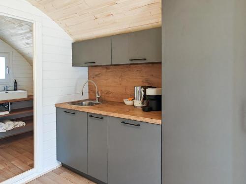 a kitchen with gray cabinets and a sink at Elm - Pantygelli Escapes in Abergavenny