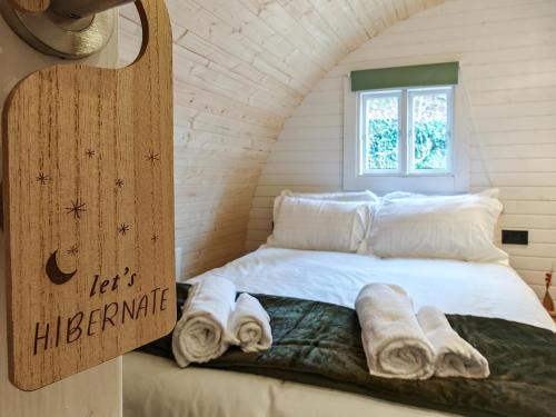 a bed in a room with towels on it at Elm - Pantygelli Escapes in Abergavenny