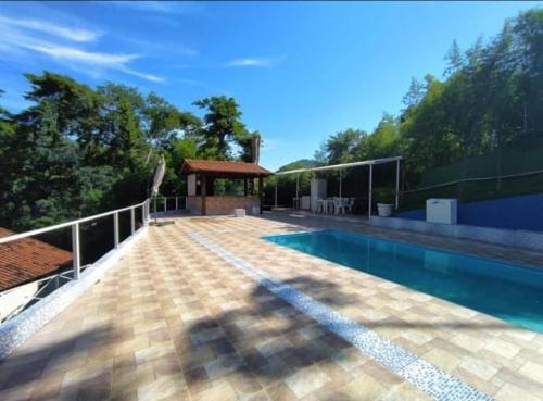 a large swimming pool with a house at Pousada Monte Libano Petropolis in Nogueira