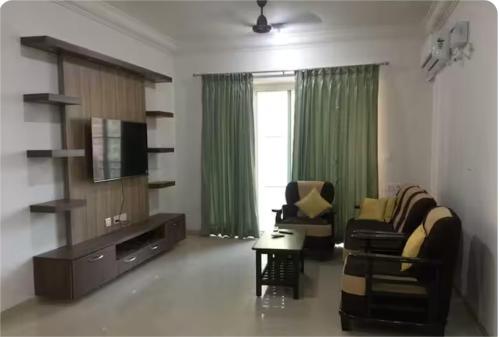 a living room with a couch and a tv at Urban Stay Service Apartments Oragadam in Oragadam