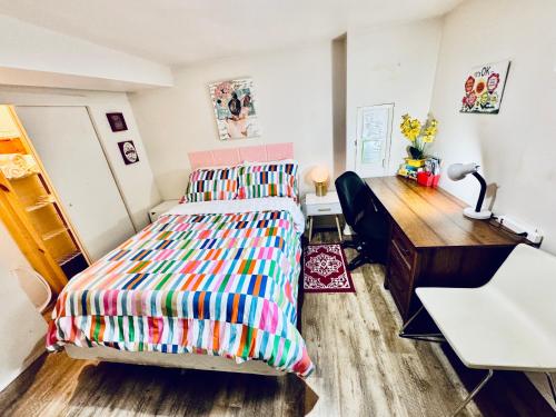 a bedroom with a desk and a bed with a colorful bedspread at Cozy Private Room with Shared Bathroom on the 1st Floor - Conveniently Located near SeaTac Airport and Downtown in Seattle