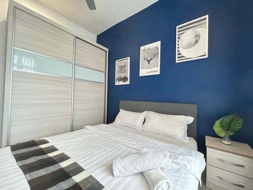 a bedroom with a large bed with a blue wall at Ipoh The Majestic Comfortable Homestay SY29 in Ipoh