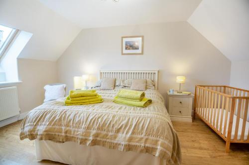 a bedroom with a bed with green pillows on it at Fferm Cwt Drecs in Llanfaethlu