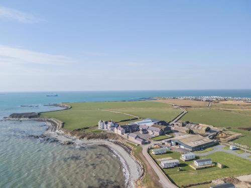 an aerial view of a house next to the ocean at Fferm Cwt Drecs in Llanfaethlu