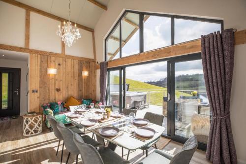 a dining room with a table and chairs and a large window at Titw Tomos Las in Berriew