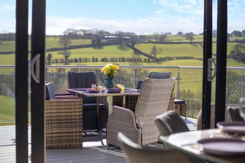 a patio with chairs and a table with flowers on it at Titw Tomos Las in Berriew