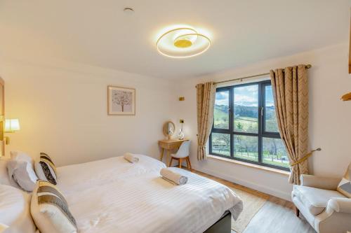 a bedroom with a bed and a window at Titw Tomos Las in Berriew