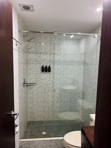 a bathroom with a glass shower with a toilet at Unicentro Rooms Inn by Saint Michel in Bogotá