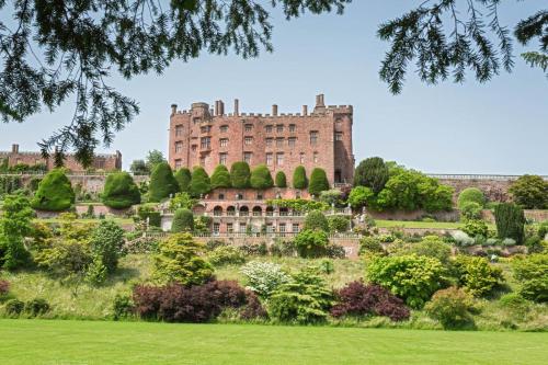 a large castle on a hill with a garden at Titw Tomos Las in Berriew