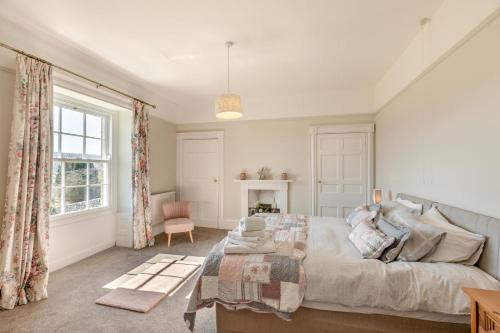 Un dormitorio con una cama grande y una ventana. en Llansantffraed House, en Hundred House