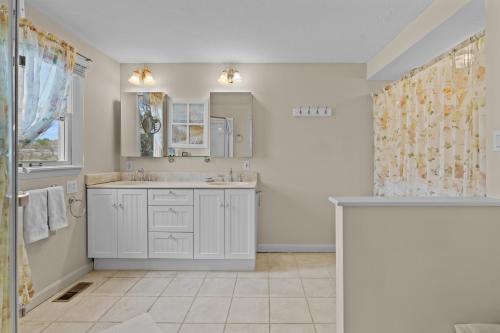 a white bathroom with a sink and a shower at Hydrangeas by the Sea in Barnstable