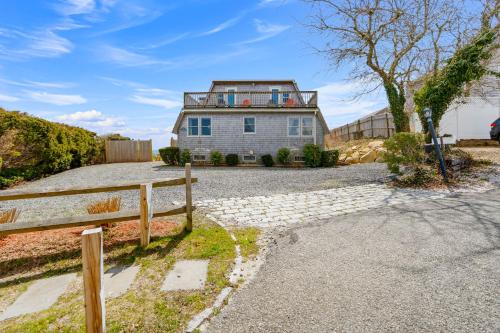 a house with a fence in front of a driveway at Hydrangeas by the Sea in Barnstable