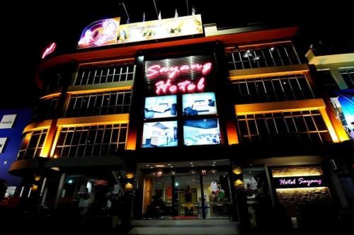 a building with neon signs on the side of it at Hotel Sayang in Kulai