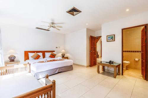 a bedroom with two beds and a bathroom at Kamala Beach Estate Resort - SHA Extra Plus in Kamala Beach