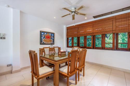 a dining room with a table and chairs and a ceiling fan at Kamala Beach Estate Resort - SHA Extra Plus in Kamala Beach