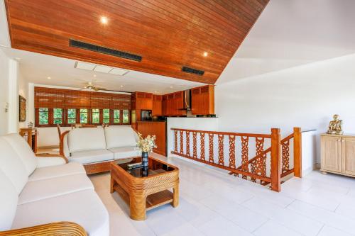 a living room with a couch and a table at Kamala Beach Estate Resort - SHA Extra Plus in Kamala Beach