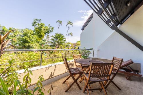 a patio with a table and chairs on a balcony at Kamala Beach Estate Resort - SHA Extra Plus in Kamala Beach