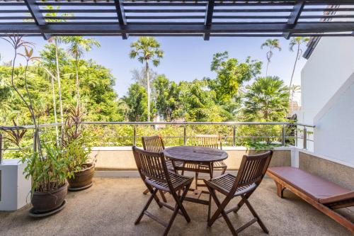 a patio with a table and chairs on a balcony at Kamala Beach Estate Resort - SHA Extra Plus in Kamala Beach