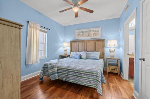 巴拿马城海滩Bright & Spacious Condo 1BD! Steps from the Beach!的蓝色卧室配有床和吊扇