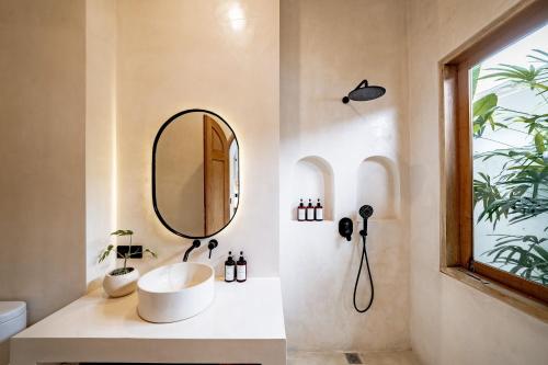 a bathroom with a sink and a mirror at Villa Kerang Sue in Munggu