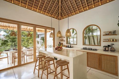 a kitchen with a large island with bar stools at Villa Kerang Sue in Munggu