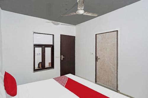 a bedroom with a bed and a ceiling fan at Hotel O Sunrise Villa in New Delhi