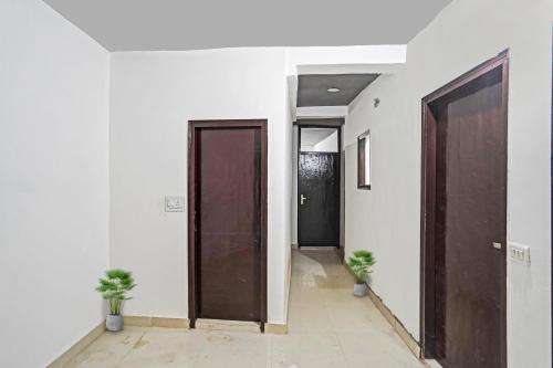 a hallway with two doors and two potted plants at Hotel O Sunrise Villa in New Delhi