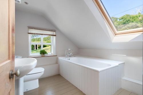 a bathroom with a white tub and a sink at Hoopers Cottage in Saint Brides