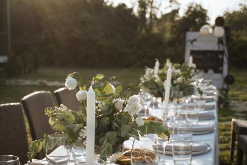 a long table with white candles and flowers on it at Matilda Village in Tʼelavi